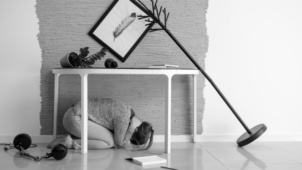 Άνθρωπος κάτω από ένα τραπέζι για να προστατευτεί από τον σεισμό.