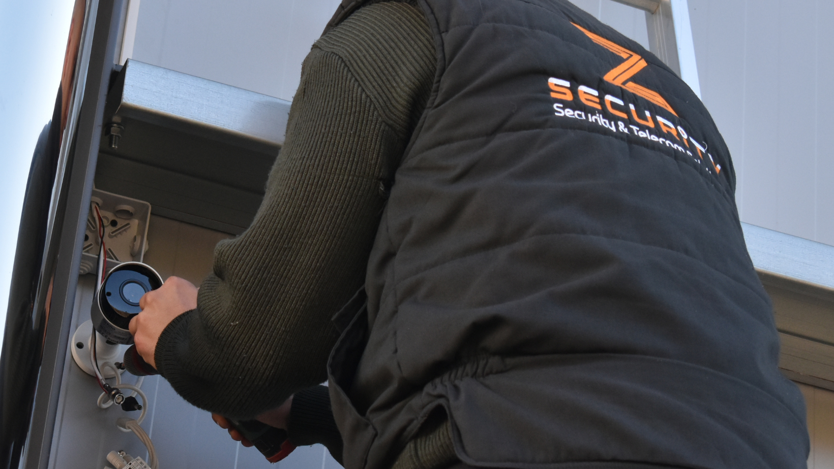 Ένας επαγγελματίας τεχνικός, τοποθετεί κάμερες ασφαλείας σε εξωτερικό χώρο